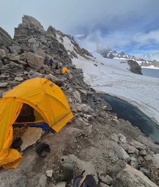 Yellow expedition tent beside a glacier