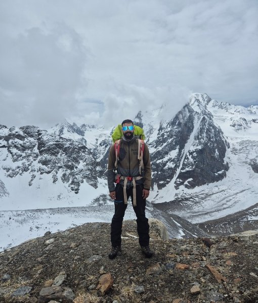 Climber standing before snow-covered Himalayan peaks