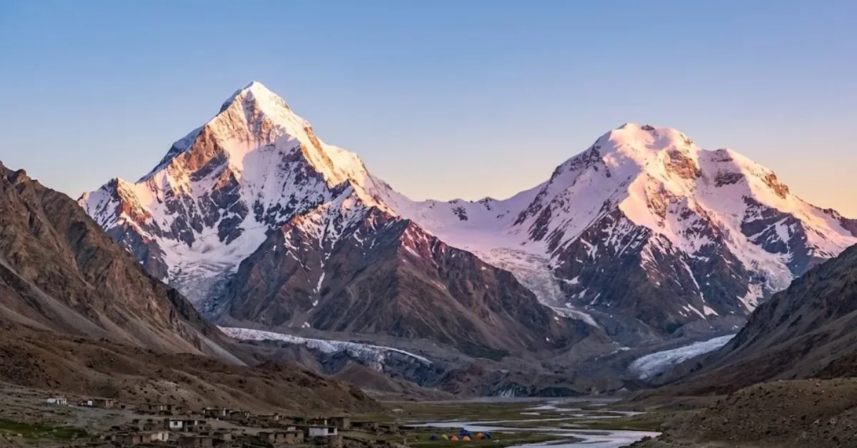 Two snow-covered peaks above a high mountain valley